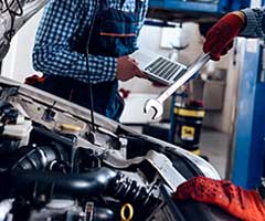 Team of employees working on hood of a car | Mark's Independent Service