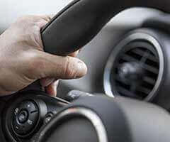Close-up of man's hand holding on to steering wheel | Mark's Independent Service